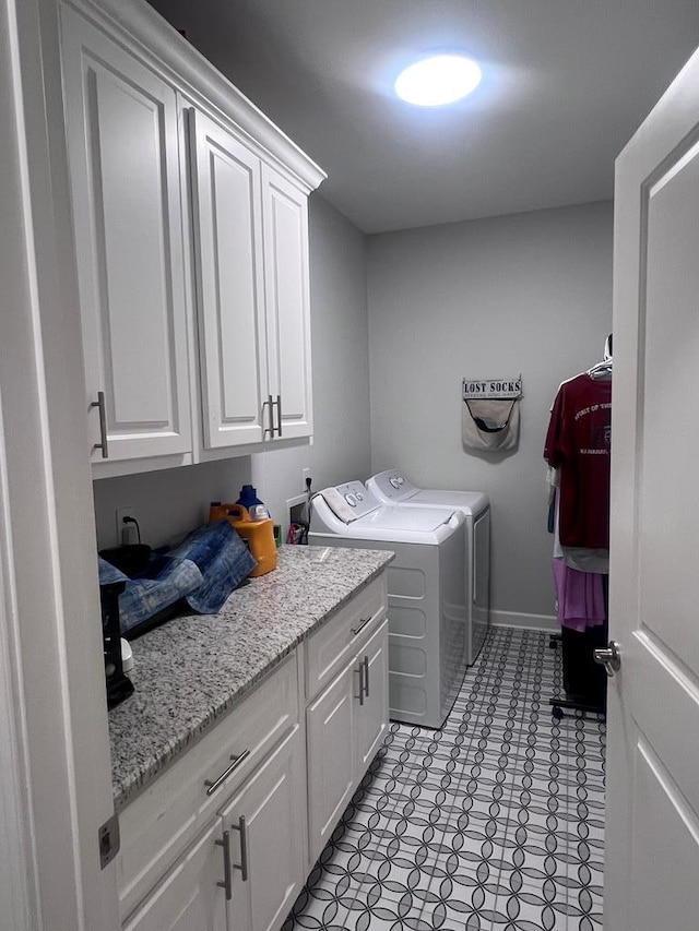 laundry room featuring cabinet space, baseboards, and washer and clothes dryer
