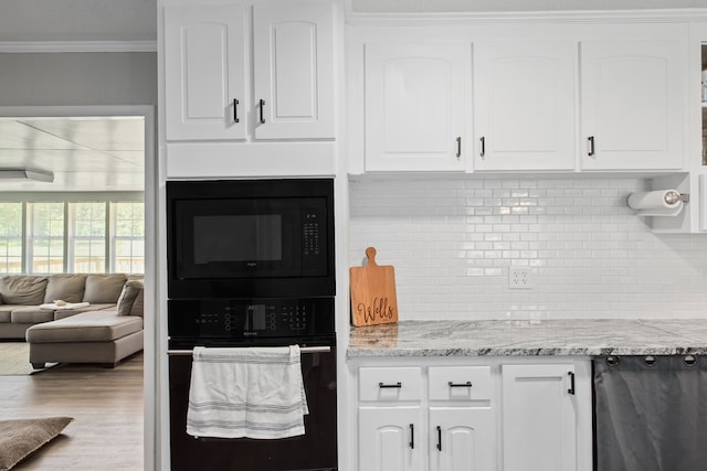 kitchen with tasteful backsplash, light stone counters, crown molding, white cabinets, and black appliances