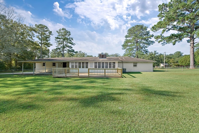 back of house featuring a lawn and a deck