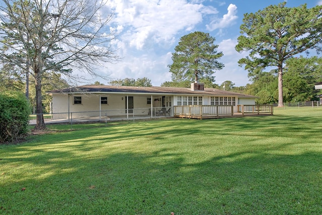 rear view of house with a lawn and a deck