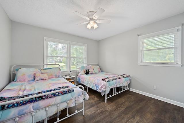 bedroom featuring ceiling fan, dark hardwood / wood-style floors, and a textured ceiling