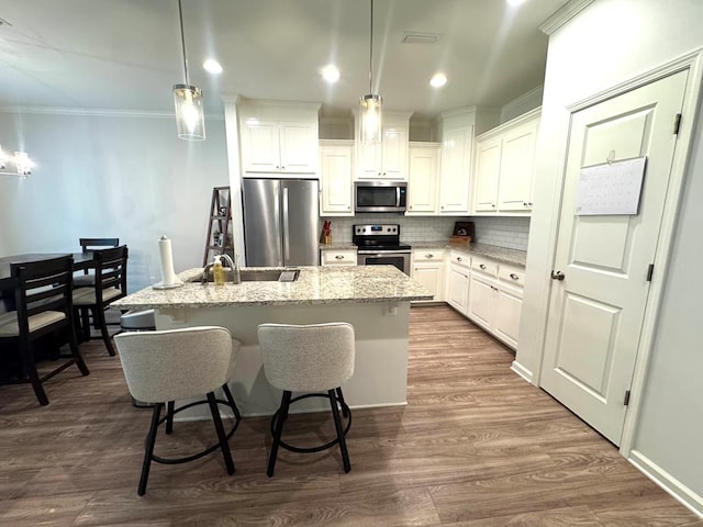 303 Courtland Dr, Dothan, AL 36301 - kitchen with stainless steel appliances, a sink, ornamental molding, a kitchen island with sink, and backsplash