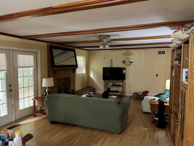 132 Ozark Rd, Abbeville, AL 36310 - living room with beam ceiling, light wood-type flooring, ceiling fan, a brick fireplace, and french doors