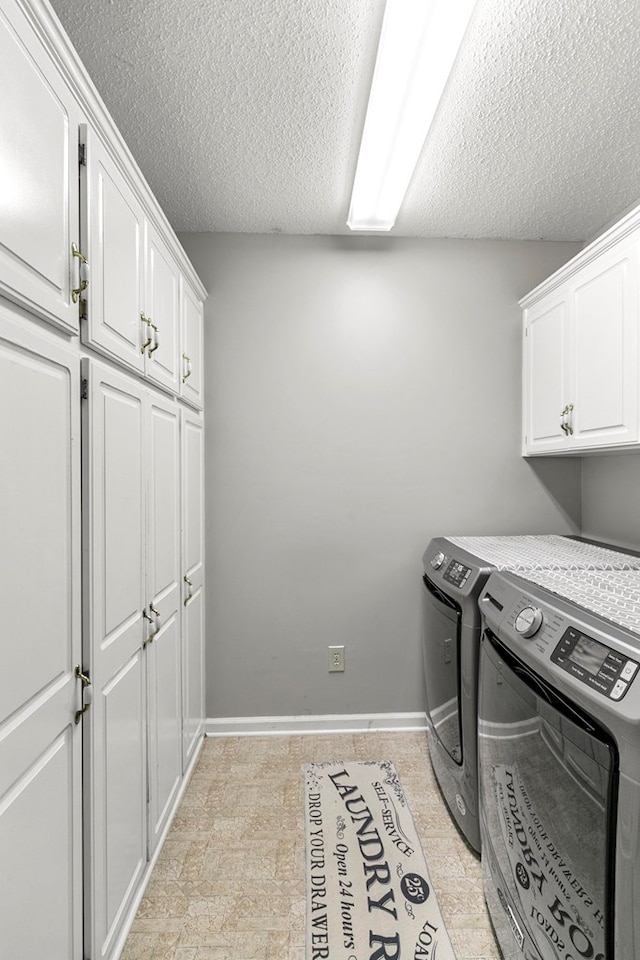 208 Willow Oaks Dr, Headland, AL 36345 - clothes washing area with a textured ceiling, washing machine and dryer, baseboards, and cabinet space