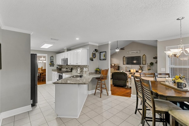 208 Willow Oaks Dr, Headland, AL 36345 - kitchen featuring crown molding, light tile patterned floors, stone countertops, a sink, and stainless steel appliances