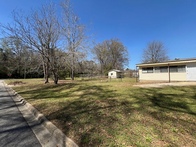 view of yard featuring an outbuilding and fence