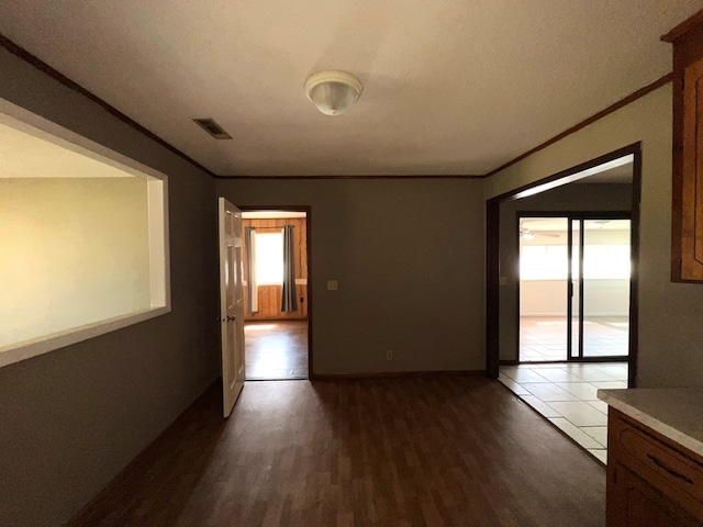 interior space featuring wood finished floors, visible vents, and ornamental molding