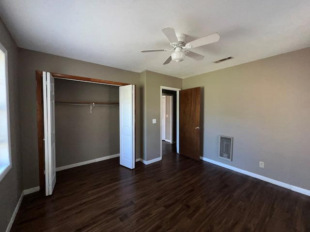 unfurnished bedroom with a closet, visible vents, baseboards, and dark wood-style flooring