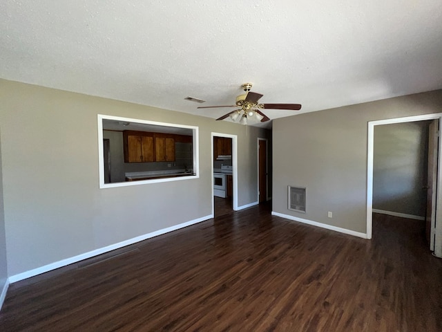 empty room with visible vents, dark wood-type flooring, and baseboards