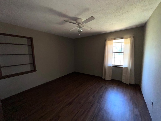 spare room with a textured ceiling, dark wood finished floors, and a ceiling fan