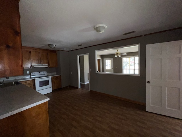 kitchen featuring brown cabinetry, a ceiling fan, dark wood finished floors, under cabinet range hood, and white electric range