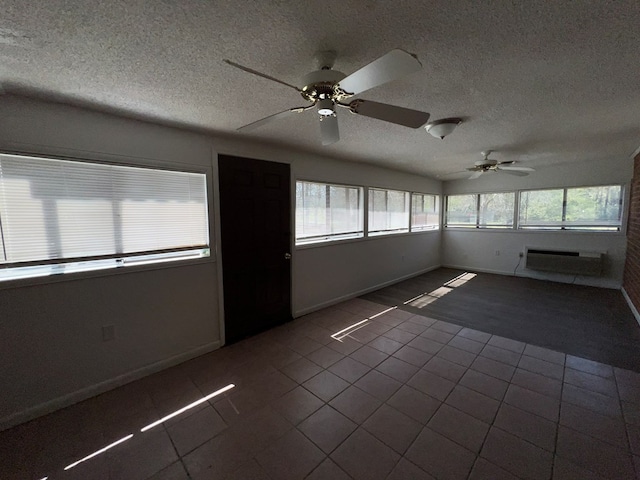 unfurnished sunroom featuring a ceiling fan and a wall mounted air conditioner