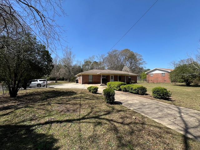 single story home featuring a front lawn, fence, brick siding, and driveway