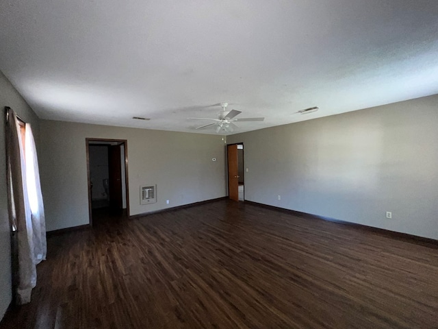 unfurnished room featuring visible vents, a ceiling fan, dark wood-style flooring, and baseboards