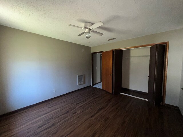 unfurnished bedroom with visible vents, a textured ceiling, dark wood-style floors, a closet, and ceiling fan