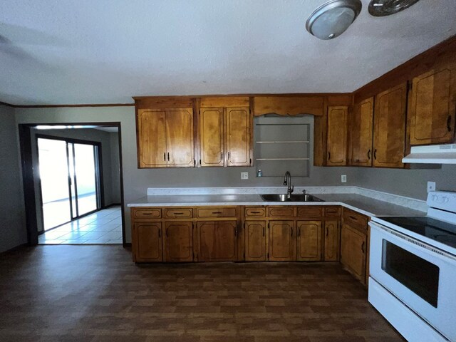 kitchen with brown cabinetry, a sink, light countertops, under cabinet range hood, and white electric range