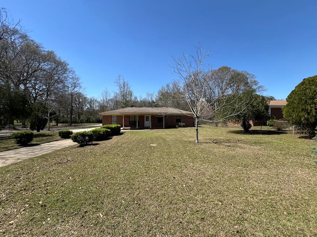 view of front of property featuring concrete driveway and a front lawn