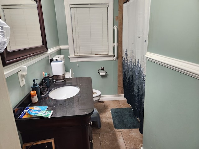 bathroom with vanity, tile patterned floors, toilet, and walk in shower