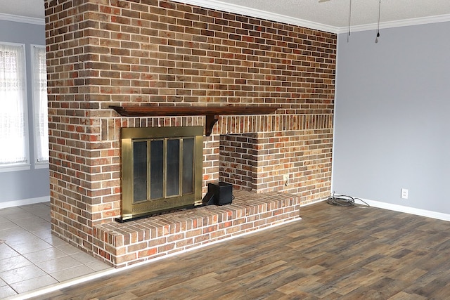 room details with baseboards, a fireplace, wood finished floors, and crown molding