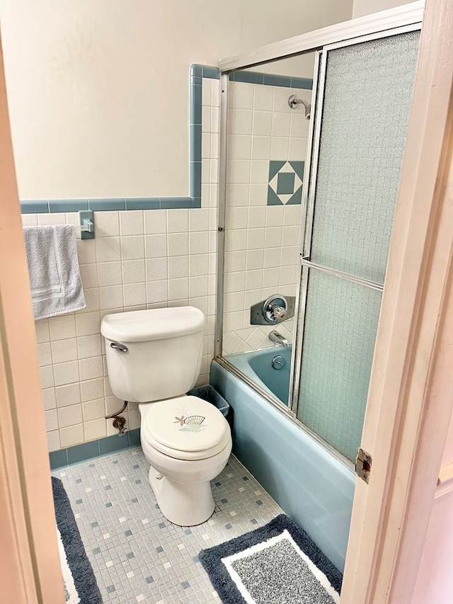 869 Bethlehem Rd, Midland City, AL 36350 - full bathroom featuring shower / bath combination with glass door, tile walls, tile patterned floors, and a wainscoted wall