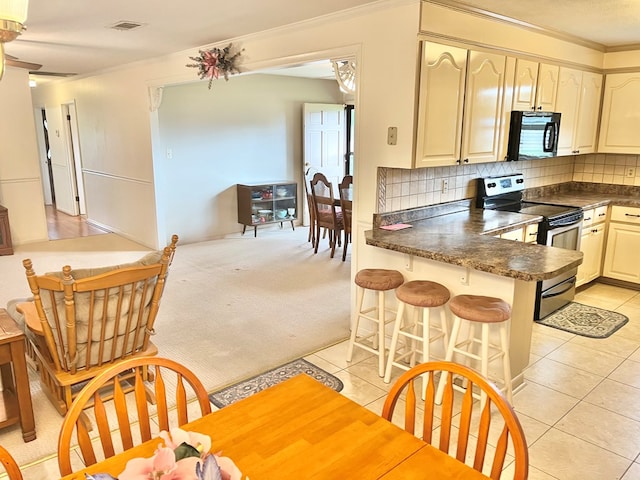 869 Bethlehem Rd, Midland City, AL 36350 - kitchen featuring stainless steel range with electric cooktop, black microwave, dark countertops, a peninsula, and light tile patterned floors