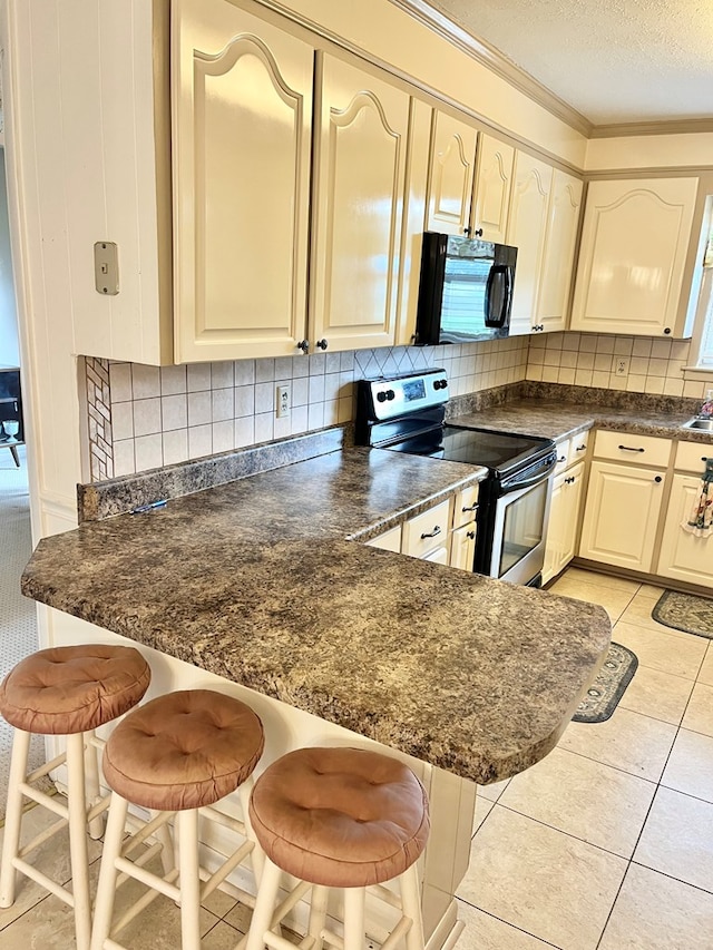 869 Bethlehem Rd, Midland City, AL 36350 - kitchen with black microwave, stainless steel range with electric cooktop, dark countertops, decorative backsplash, and a peninsula