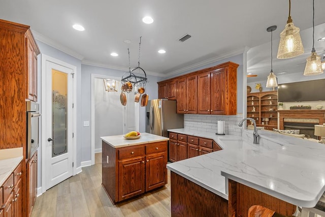 306 Halifax Dr, Dothan, AL 36305 - kitchen with ornamental molding, a peninsula, light wood finished floors, stainless steel appliances, and backsplash