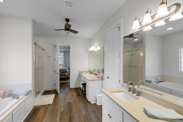 306 Halifax Dr, Dothan, AL 36305 - full bathroom with a ceiling fan, a stall shower, vanity, wood finished floors, and a bath