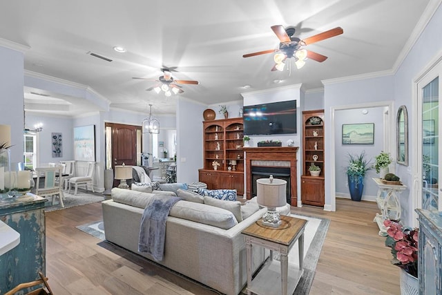 306 Halifax Dr, Dothan, AL 36305 - living area with a fireplace, a ceiling fan, light wood-style flooring, crown molding, and a chandelier