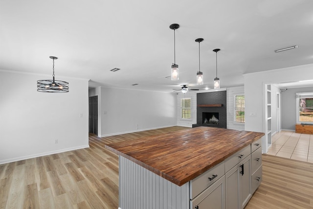 1005 Rampart Dr, Dothan, AL 36303 - kitchen with butcher block countertops, open floor plan, plenty of natural light, a fireplace, and crown molding