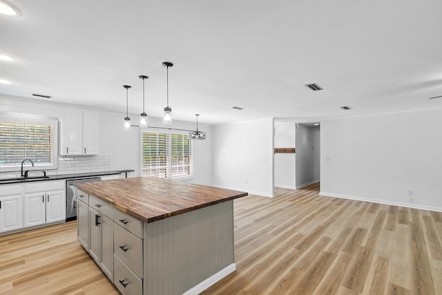 1005 Rampart Dr, Dothan, AL 36303 - kitchen featuring wood counters, stainless steel dishwasher, a center island, backsplash, and light wood finished floors