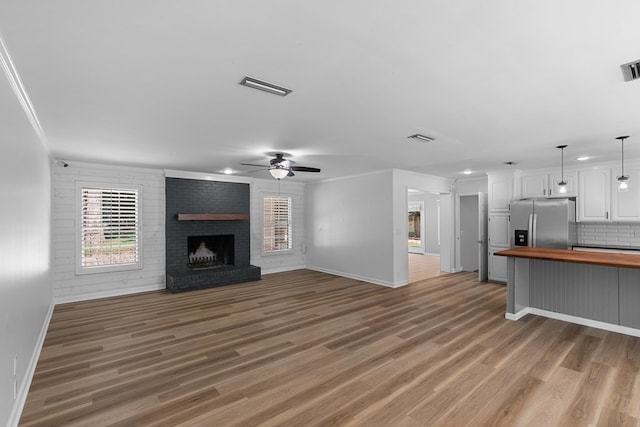 1005 Rampart Dr, Dothan, AL 36303 - unfurnished living room featuring light wood-type flooring, a brick fireplace, ceiling fan, crown molding, and recessed lighting