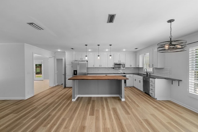 1005 Rampart Dr, Dothan, AL 36303 - kitchen with wood counters, stainless steel appliances, white cabinetry, backsplash, and recessed lighting