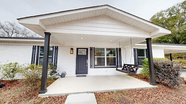 view of exterior entry featuring covered porch