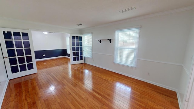 spare room featuring wood-type flooring and ornamental molding