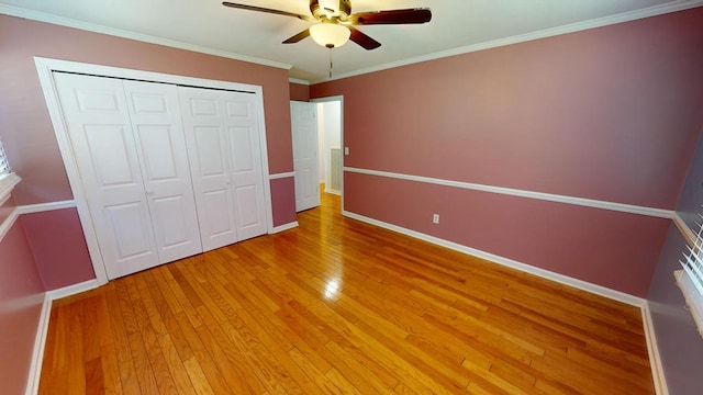 unfurnished bedroom featuring wood-type flooring, a closet, ceiling fan, and ornamental molding