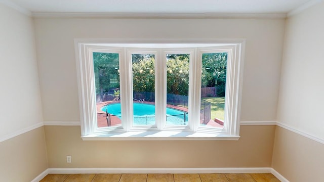 interior space featuring light tile patterned floors and crown molding