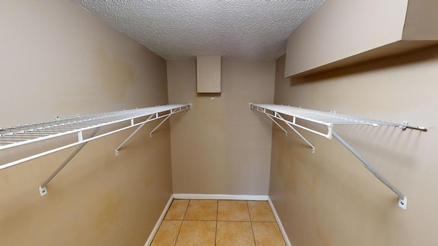 walk in closet with light tile patterned floors