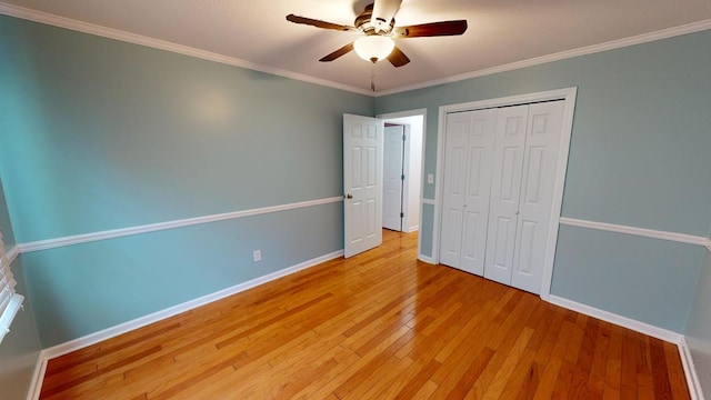 unfurnished bedroom with a closet, light hardwood / wood-style flooring, ceiling fan, and ornamental molding