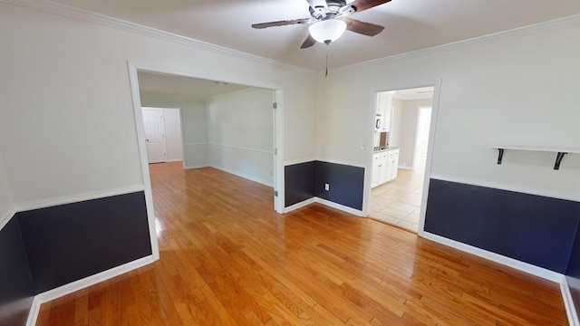 empty room with ceiling fan, light wood-type flooring, and crown molding