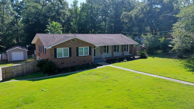 single story home featuring an outbuilding, a front lawn, a porch, and a garage