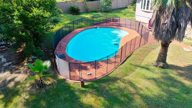 view of swimming pool with a yard