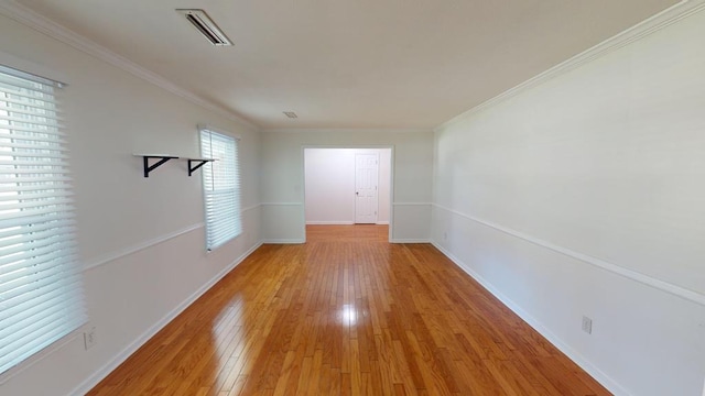 interior space with a wealth of natural light, light hardwood / wood-style floors, and ornamental molding