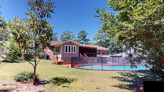 view of pool with a sunroom and a lawn