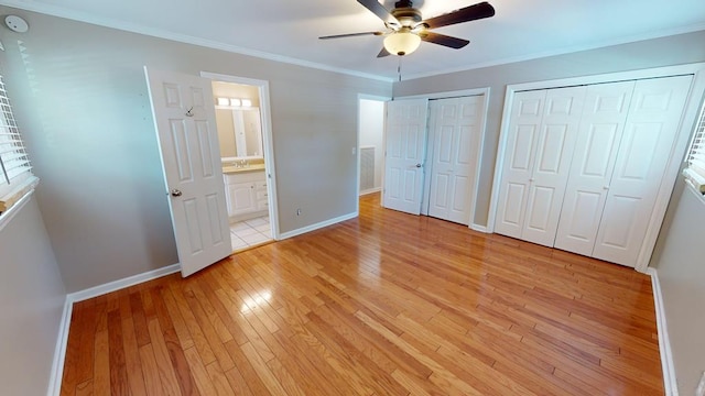 unfurnished bedroom with ceiling fan, light hardwood / wood-style flooring, ensuite bathroom, two closets, and ornamental molding