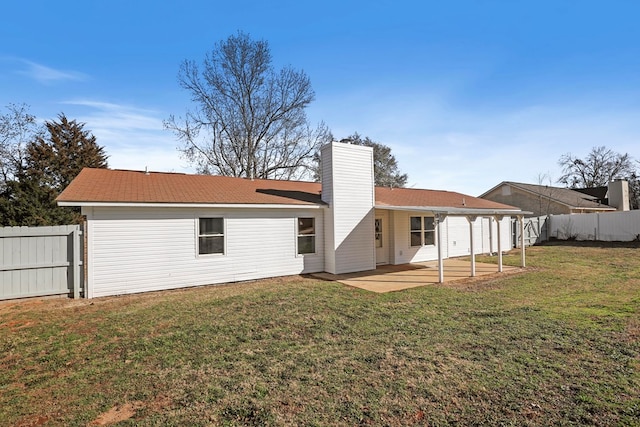 rear view of property with a yard and a patio area