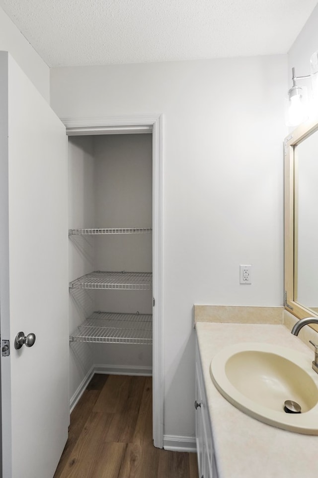 bathroom featuring vanity, hardwood / wood-style floors, and a textured ceiling