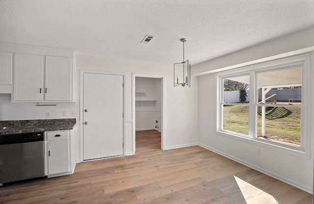 kitchen featuring pendant lighting, white cabinetry, a textured ceiling, stainless steel dishwasher, and light wood-type flooring