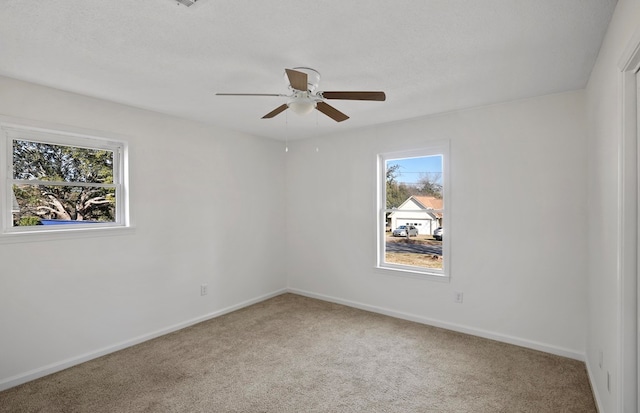 carpeted empty room featuring ceiling fan, a healthy amount of sunlight, and a textured ceiling