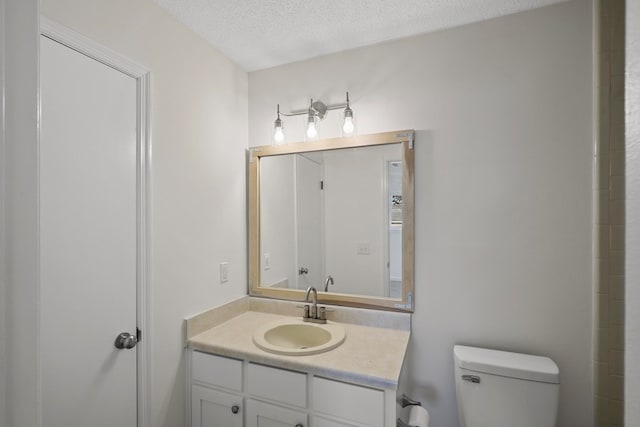 bathroom featuring vanity, toilet, and a textured ceiling